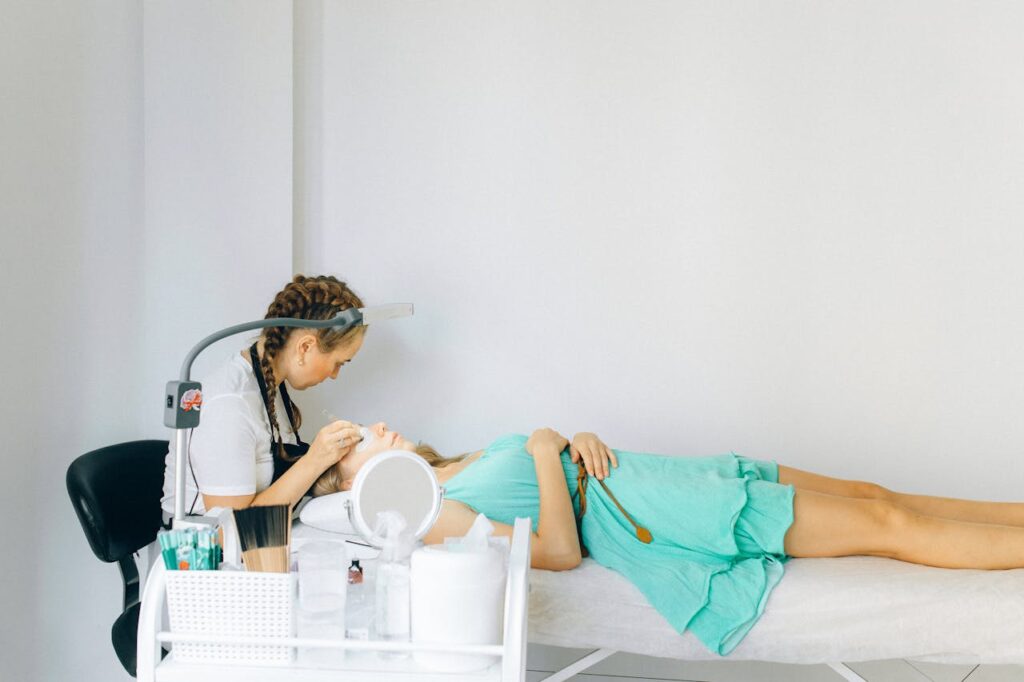 Woman in Blue T-shirt and Blue Shorts Sitting on Bed